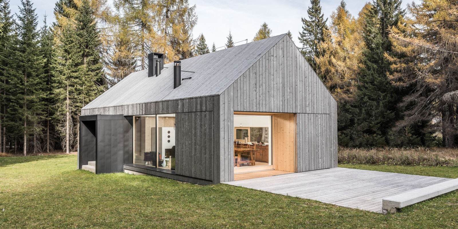 casa in legno grigio nel bellunese in mezzo al bosco