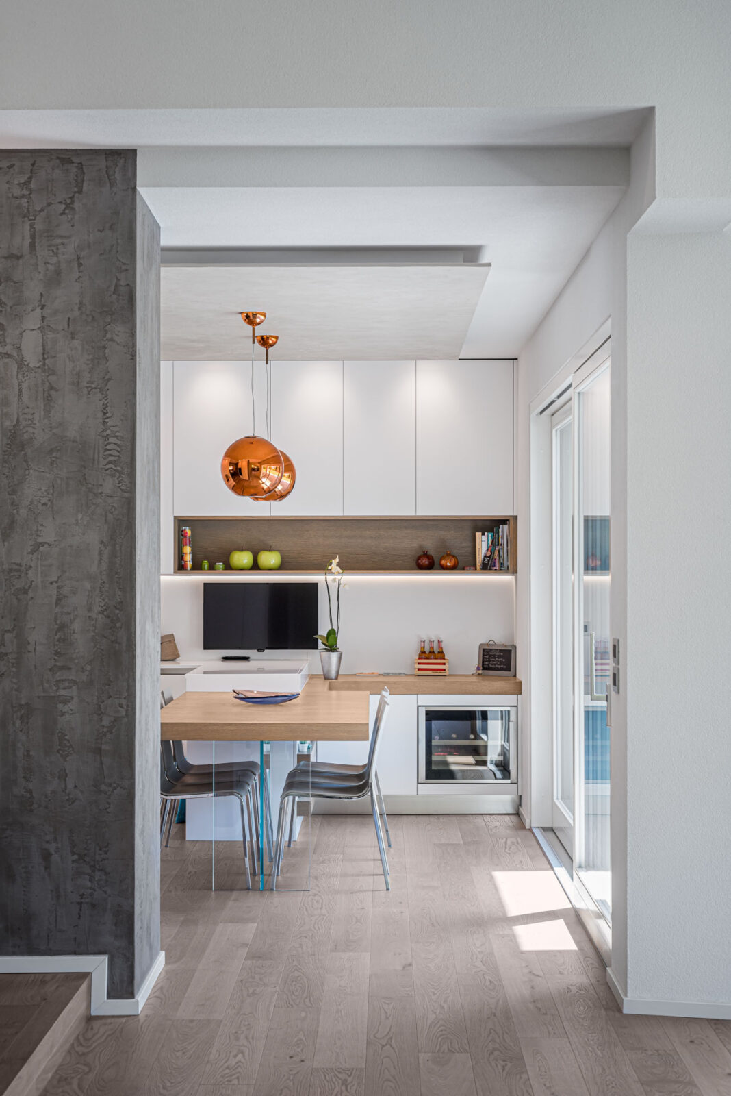 cucina di una casa modernacon pavimento in legno e mobili bianchi