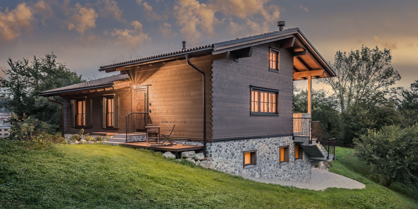 casa in stile baita di montagna in legno scuro e base in pietra - foto di architettura notturna