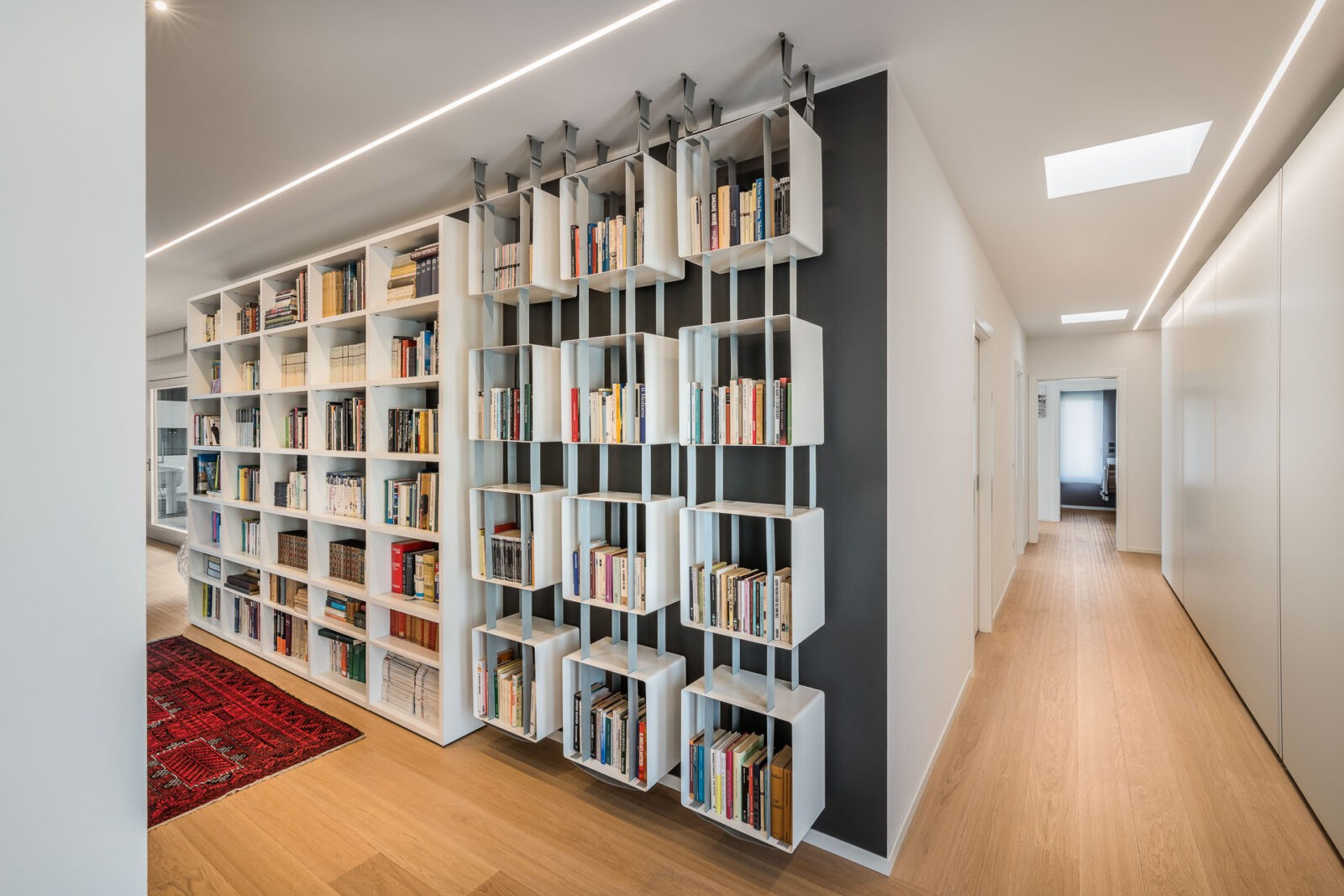 libreria moderna appesa al soffitto lungo corridoio bianco - foto di architettura d'interni