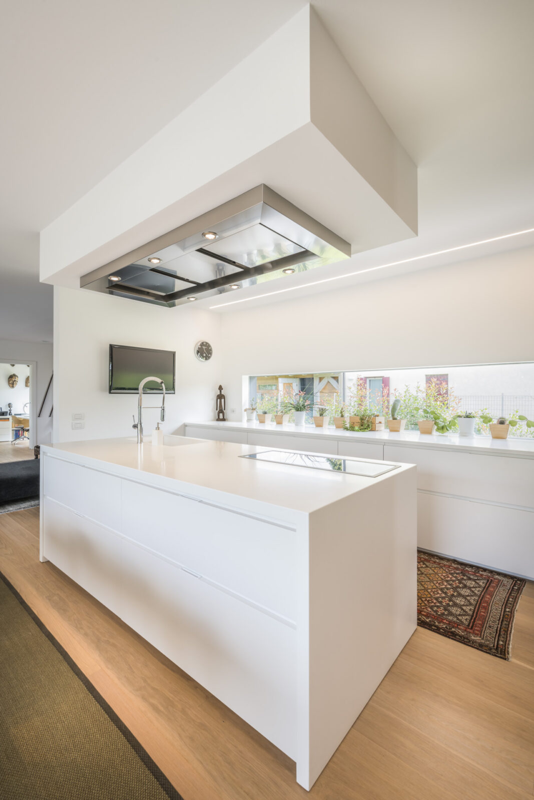 cucina moderna di lusso bianca con pavimento in legnoe piante grasse