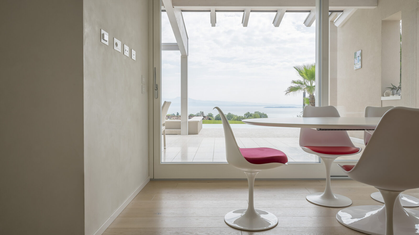 cucina moderna color pastello sul Lago di Garda con grande vetrata e vista sulla piscina - atmosfera rilassante