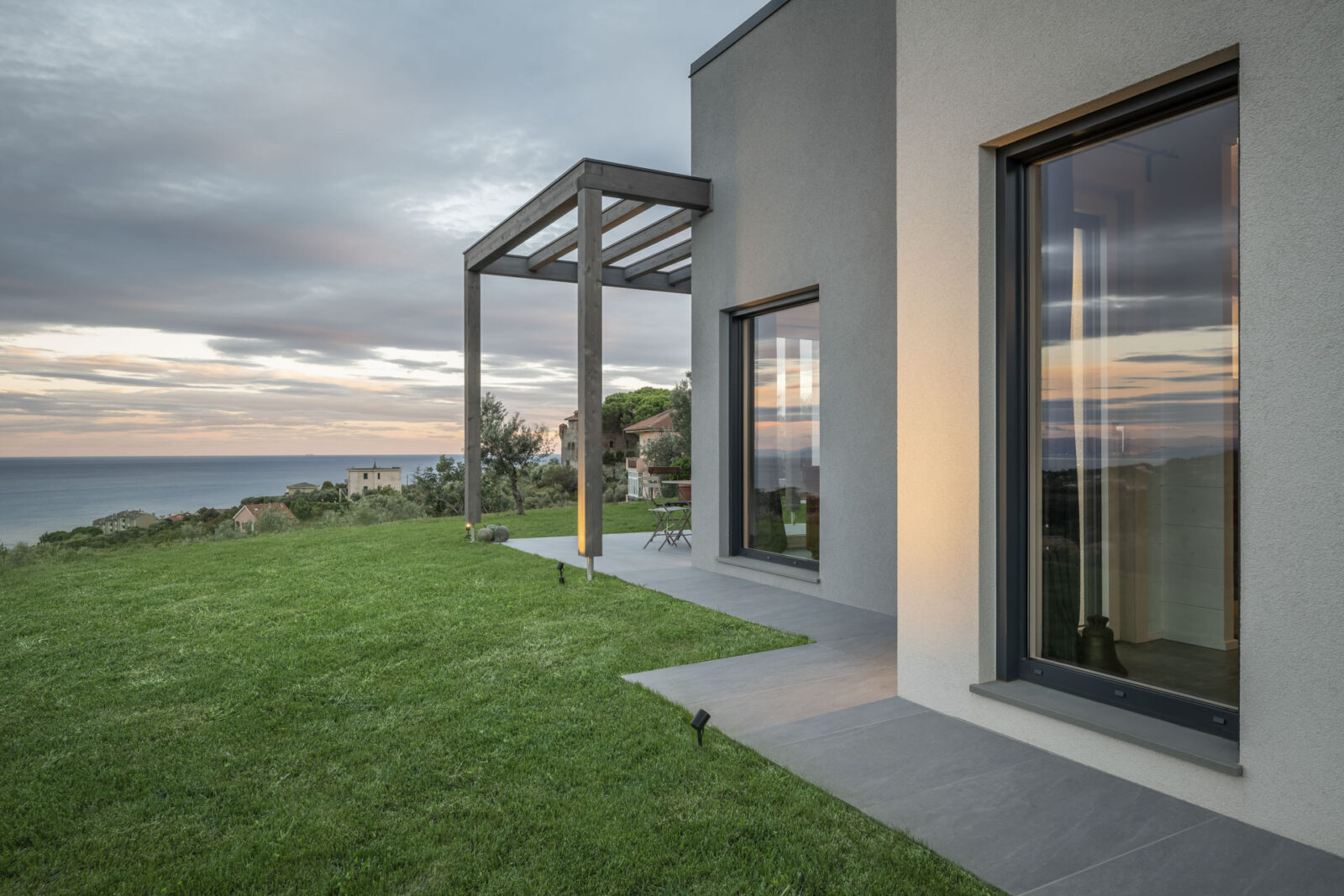 villa moderna con grandi vetrate su una collina nel verde in Liguria