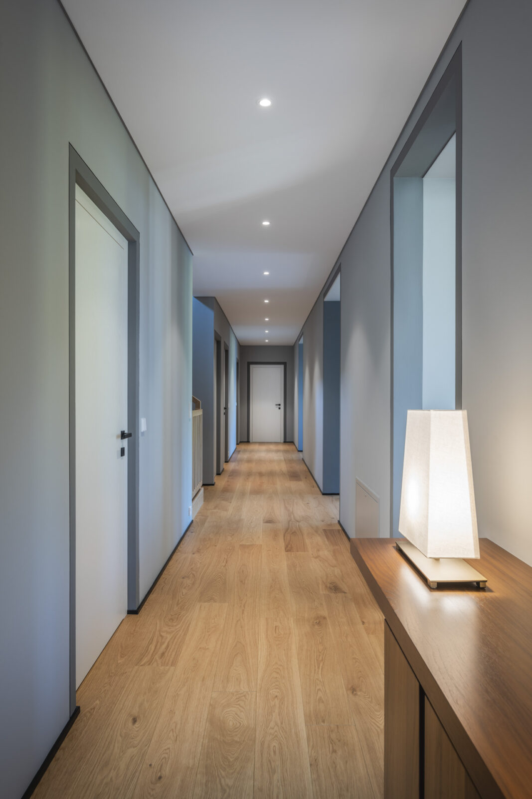 corridoio di casa di lusso con pavimento in legno e pareti azzurre