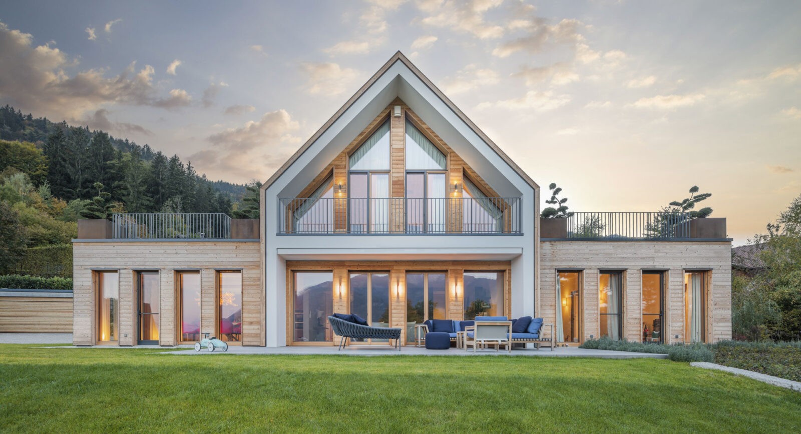 Villa moderna in legno immarsa nel verde al tramonto - foto di architettura professionale