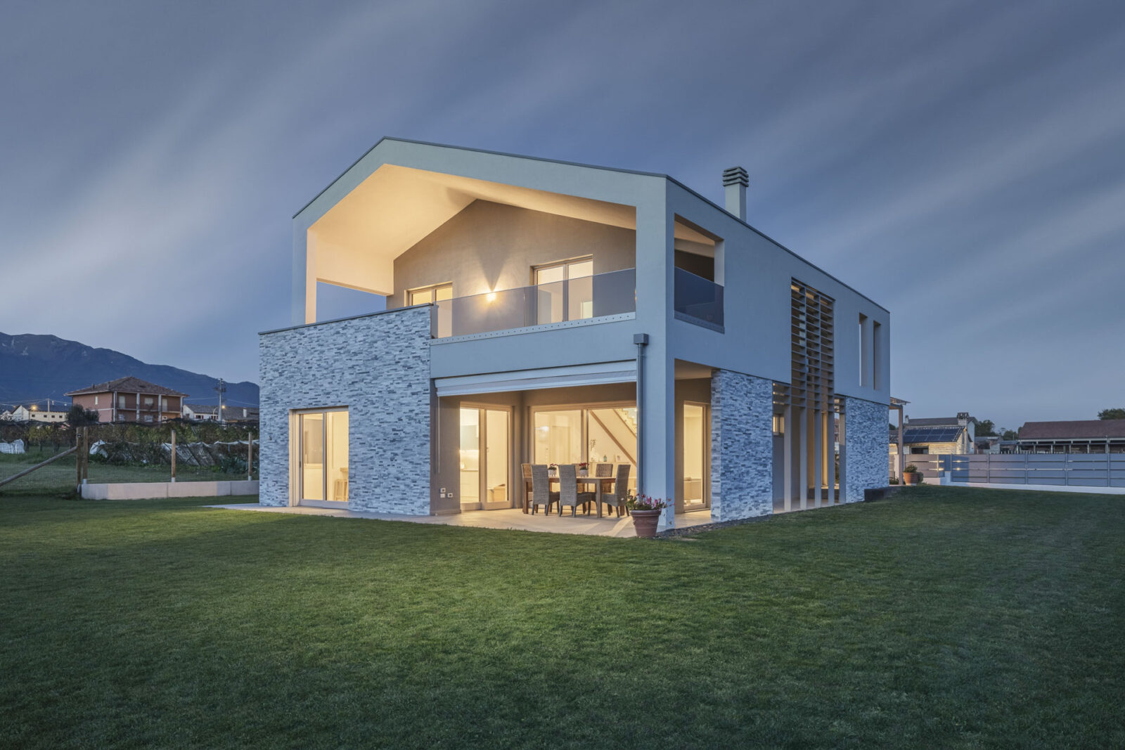 casa moderna con grande prato verde e patio - fotografia di architettura in notturna